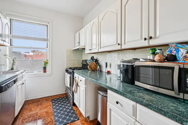a kitchen with stainless steel appliances granite countertop a sink stove and cabinets
