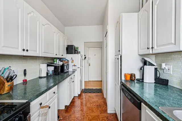 a kitchen with stainless steel appliances granite countertop a sink a stove and a refrigerator