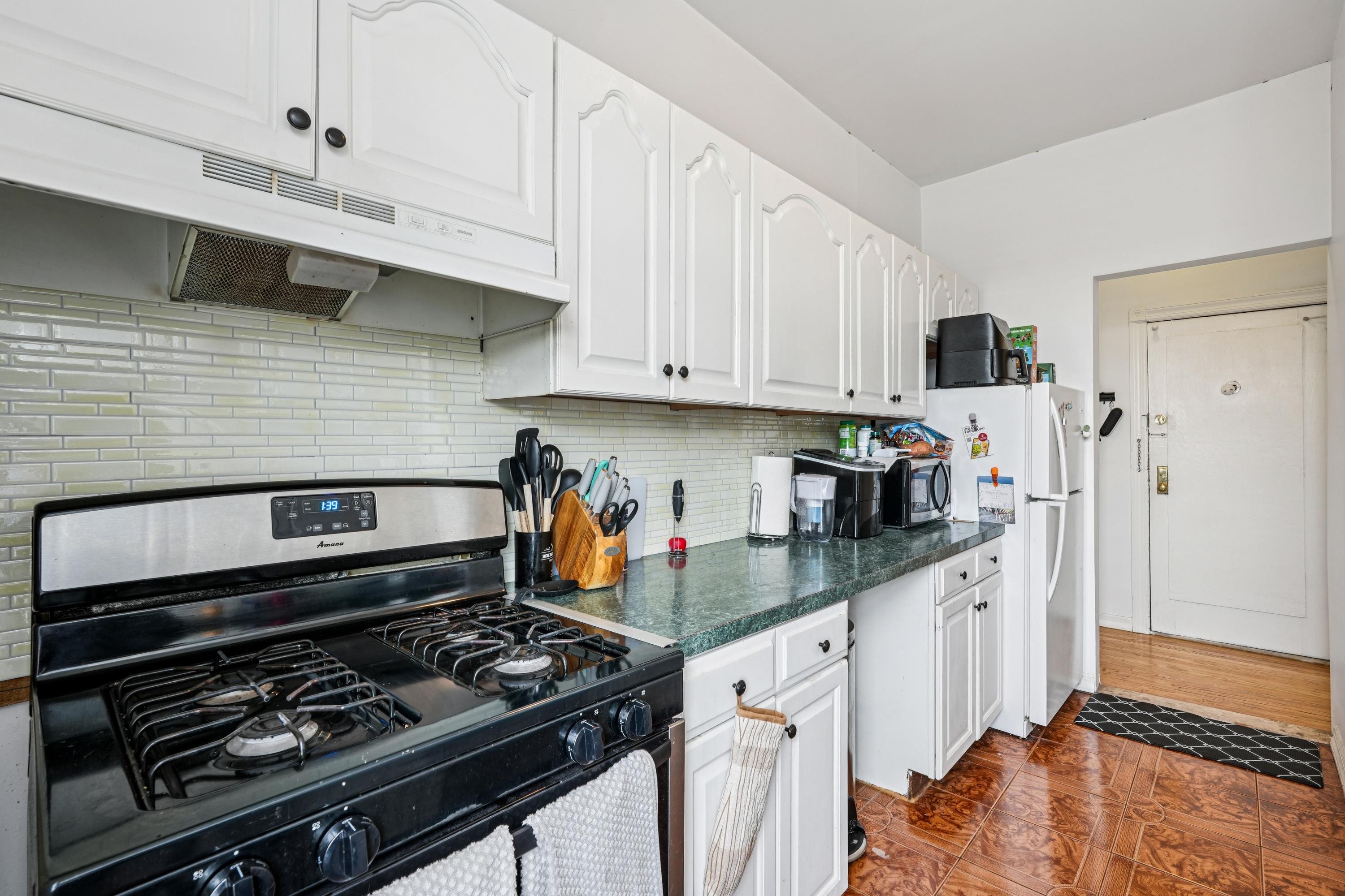 851 Boulevard East, Unit D2 Weehawken, NJ 07086 - Photo 21 of 42 a kitchen with stainless steel appliances granite countertop a stove and white cabinets