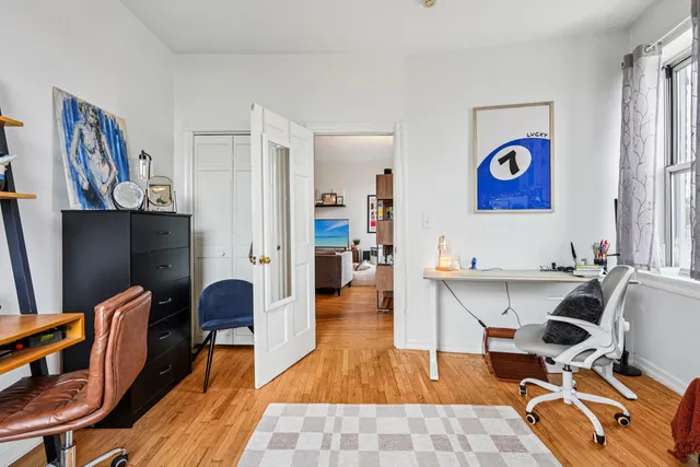 a workspace with furniture wall paintings and a window