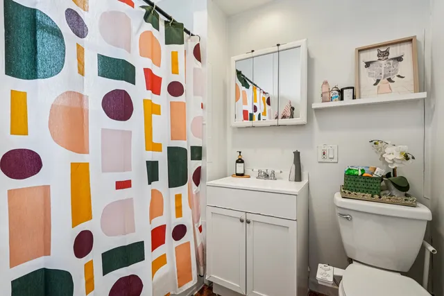 a bathroom with a sink a toilet and shower curtain