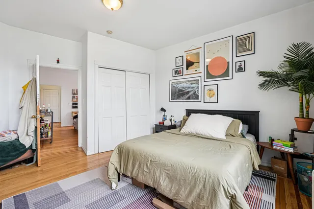 a bedroom with a bed and painting on the wall
