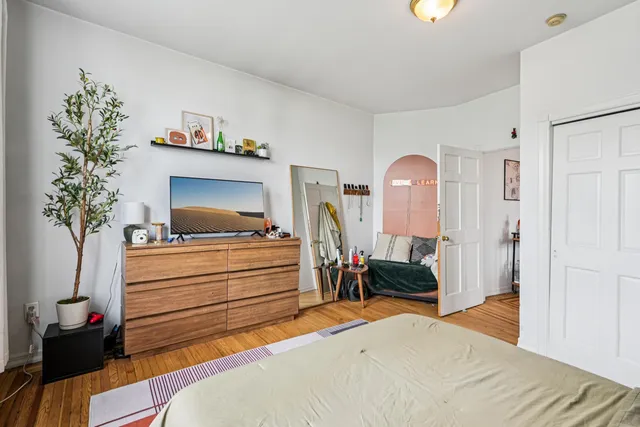 a bedroom with a bed and a potted plant