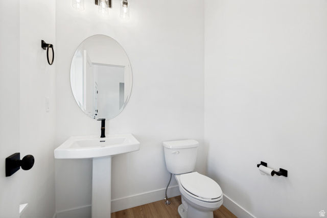 1351 Maple Circle Santaquin, UT 84655 - Photo 5 of 42 Bright powder room featuring a white pedestal sink, oval mirror, and contemporary lighting fixture