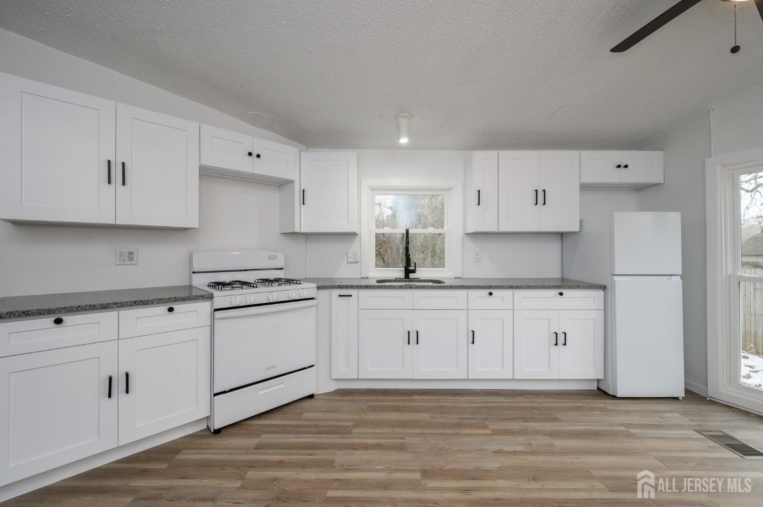 448 Evergreen Road Millville, NJ 08332 - Photo 6 of 29 a large white kitchen with granite countertop white cabinets and stainless steel appliances