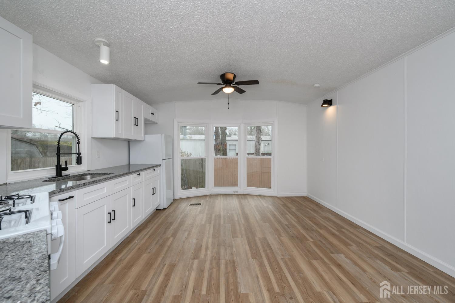 448 Evergreen Road Millville, NJ 08332 - Photo 7 of 29 a large kitchen with granite countertop a stove top oven a sink with wooden floors