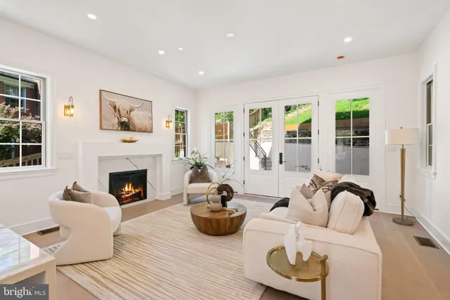 a living room with furniture a fireplace and a floor to ceiling window