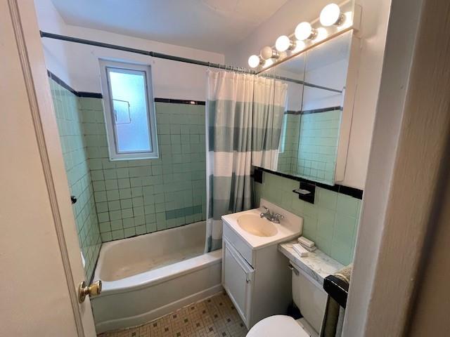 216-21 73rd Avenue, Unit 1 Queens, NY 11364 - Photo 12 of 12 Full bathroom with shower / bath combo with shower curtain, vanity, tile walls, and toilet