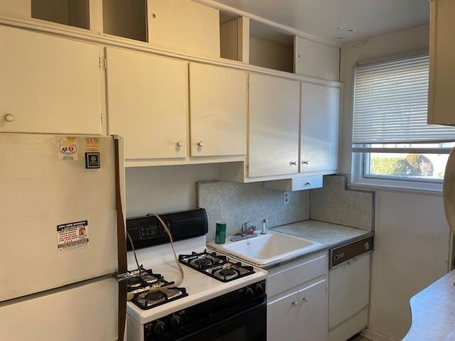 216-21 73rd Avenue, Unit 1 Queens, NY 11364 - Photo 8 of 12 Kitchen featuring white cabinetry, white appliances, sink, and decorative backsplash