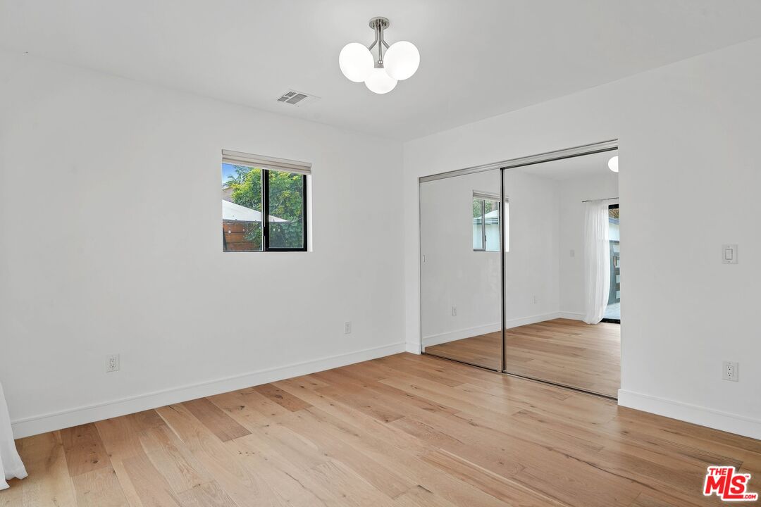 5922 Wrightcrest Drive Culver City, CA 90232 - Photo 12 of 25 an empty room with wooden floor chandelier fan and windows