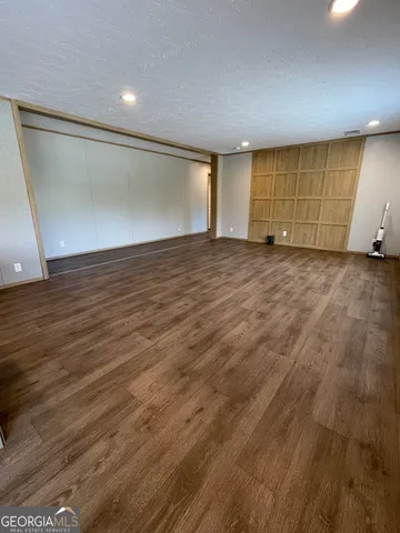 a kitchen with granite countertop wooden cabinets a sink and a large window