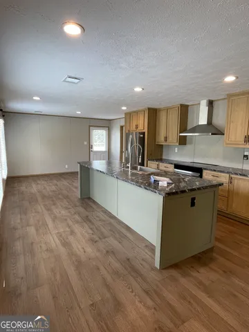 a large kitchen with stainless steel appliances a large counter top