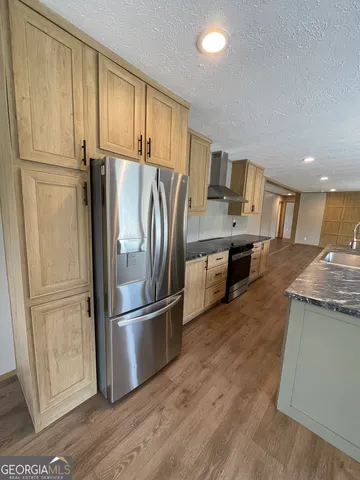 an empty room with wooden floor and entrance