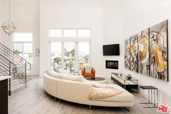 a living room with furniture a flat screen tv and a large window
