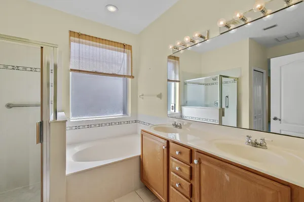 a bathroom with a granite countertop sink mirror and a bathtub