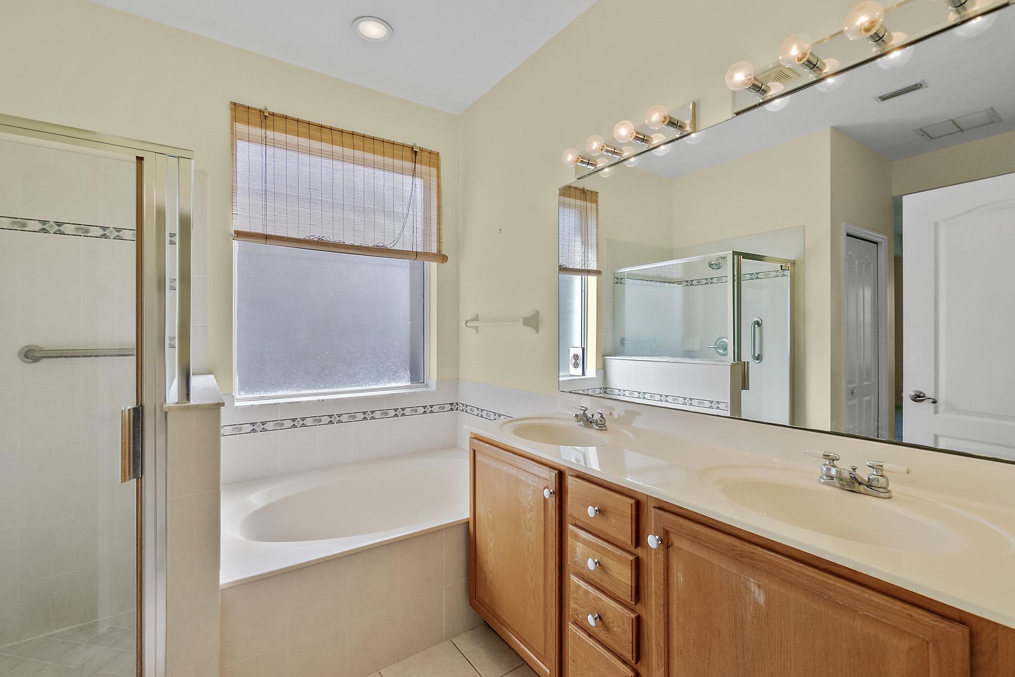 644 Casa Fuerta Lane St. Augustine, FL 32080 - Photo 30 of 49 a bathroom with a granite countertop sink mirror and a bathtub