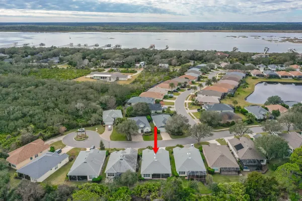 an aerial view of residential houses with outdoor space and ocean view
