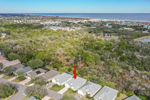 an aerial view of residential houses with outdoor space and trees