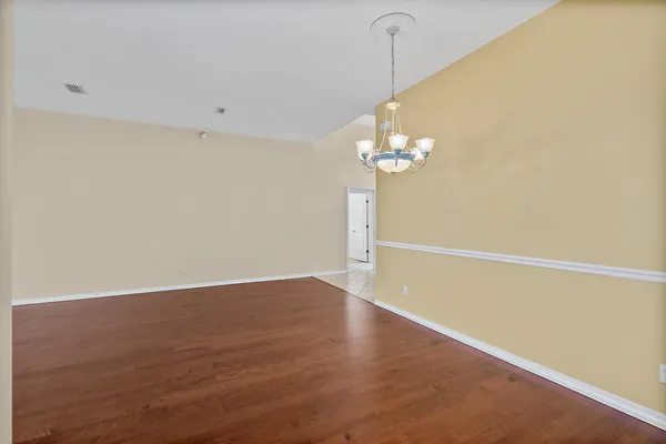 a view of a room with wooden floor and chandelier