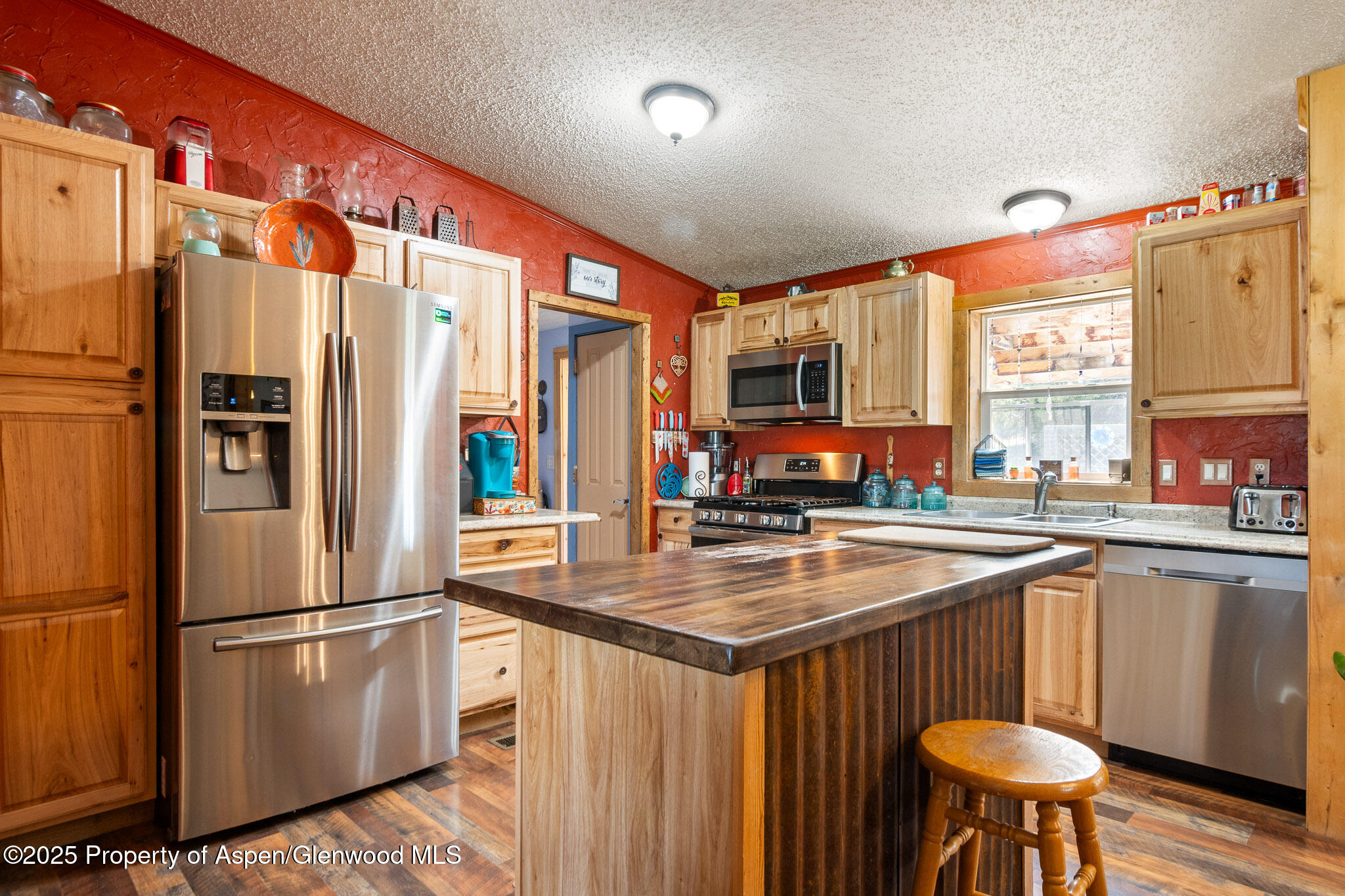 3768 County Road 237 Rifle, CO 81650 - Photo 12 of 47 a kitchen with stainless steel appliances granite countertop a refrigerator a sink dishwasher a stove with white cabinets and wooden floor