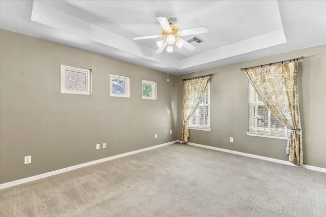 an empty room with chandelier fan