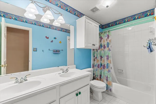 an empty room with a chandelier fan and windows