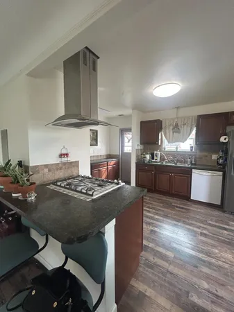 a kitchen with kitchen island a stove and a refrigerator
