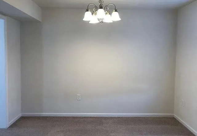 a view of a room with a chandelier fan