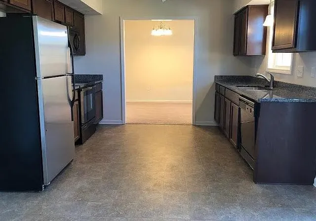 a kitchen with stainless steel appliances granite countertop a refrigerator and a sink