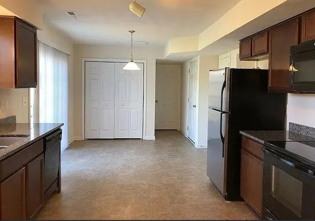 a kitchen with stainless steel appliances granite countertop a refrigerator and a sink