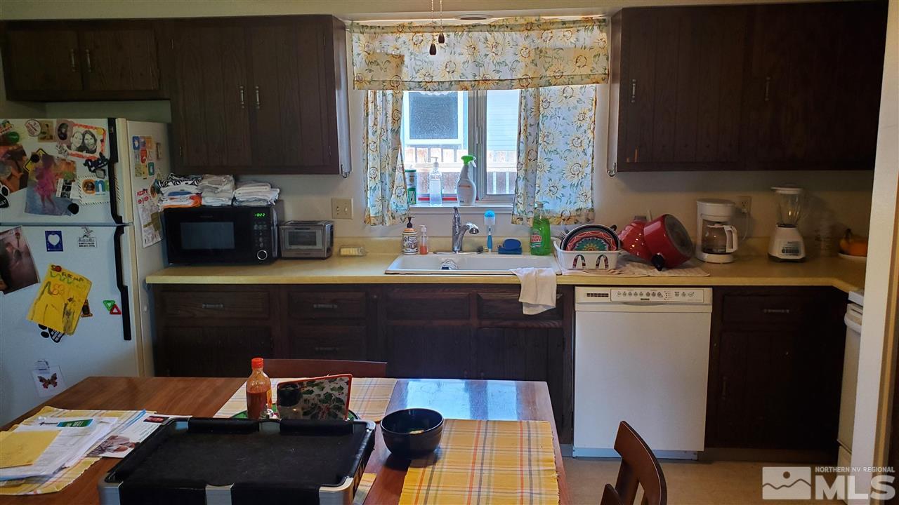 605 Lander Street Reno, NV 89509 - Photo 5 of 17 a kitchen with a refrigerator and a stove top open