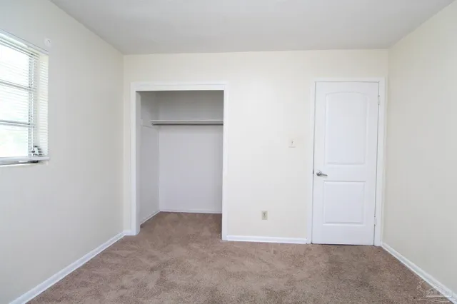 an empty room with windows and closet