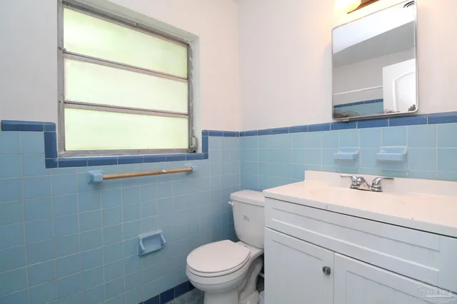 a bathroom with a sink a toilet and a window