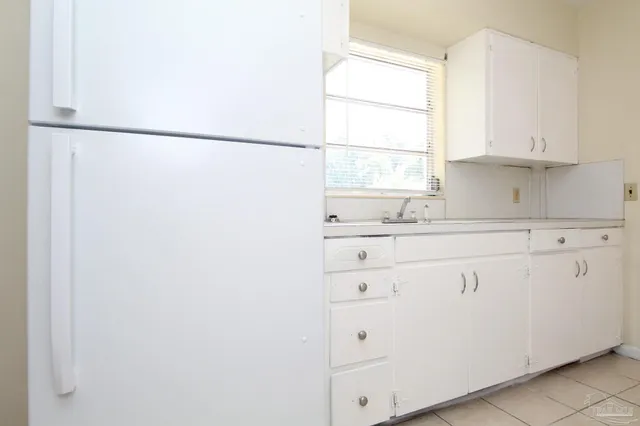 a kitchen with cabinets appliances a sink and a window