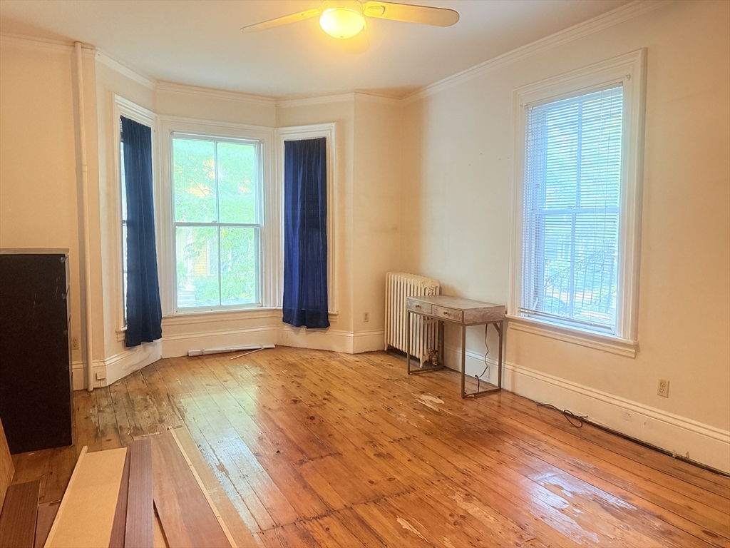 23 Inman Street, Unit 1 Cambridge, MA 02139 - Photo 19 of 20 a view of an empty room with a window and wooden floor