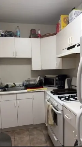a kitchen with granite countertop a stove sink and cabinets