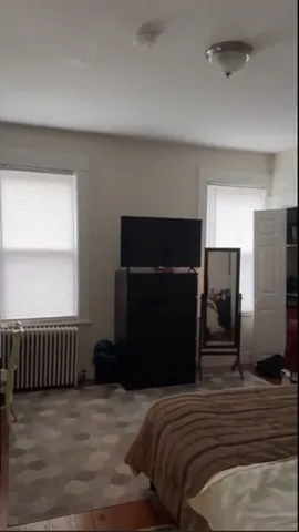 a bedroom with a bed and a television