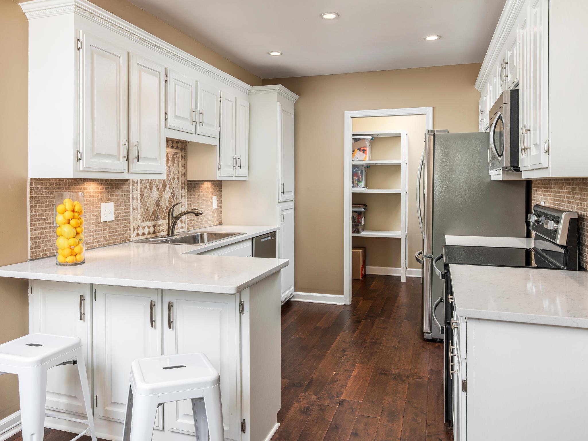 732 General George Patton Road, Unit 732 Nashville, TN 37221 - Photo 11 of 27 a kitchen with stainless steel appliances a sink a stove a refrigerator cabinets and wooden floor