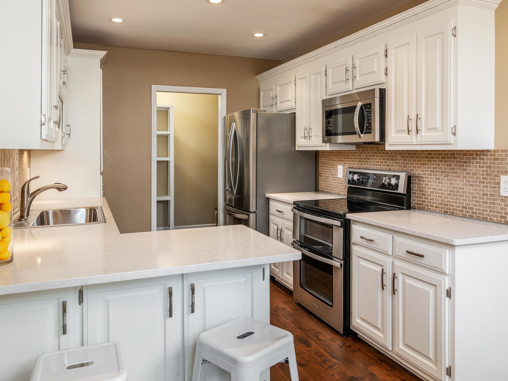 732 General George Patton Road, Unit 732 Nashville, TN 37221 - Photo 14 of 27 a kitchen with stainless steel appliances a white stove top oven and sink