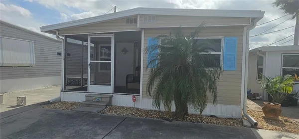 a yellow house with a potted plant in front of door