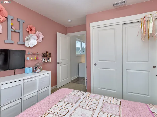 a room with a bed and a mirror on dresser