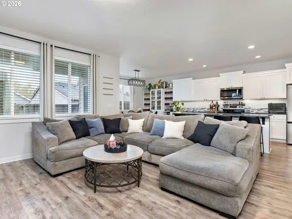 a living room with furniture kitchen and a large window