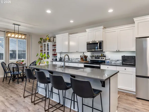 a kitchen with a dining table chairs and a refrigerator