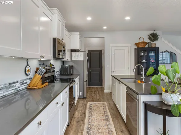 a kitchen with stainless steel appliances granite countertop a sink a stove and a refrigerator