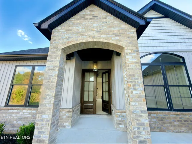 a view of kitchen with granite countertop white cabinets and stainless steel appliances