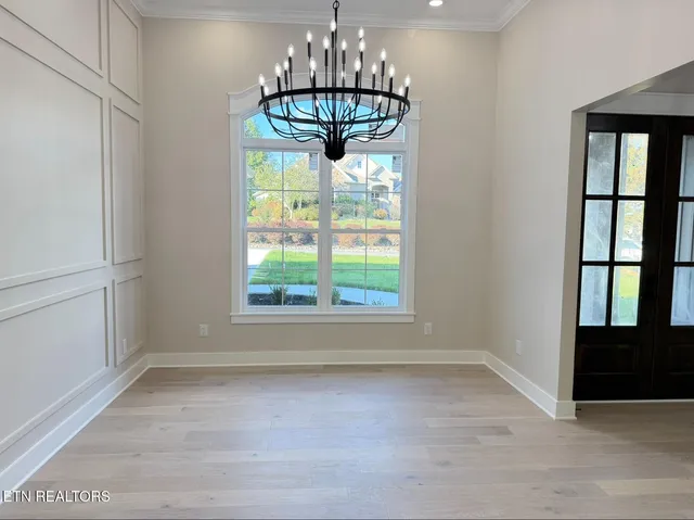 a view of an empty room with a kitchen and entryway