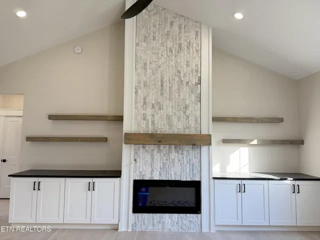 a large kitchen with stainless steel appliances a large counter top a sink a refrigerator and a stove