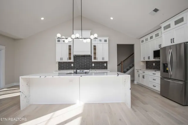 a kitchen with stainless steel appliances a stove a sink and a refrigerator