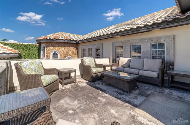 a view of a patio with couches chairs and wooden floor