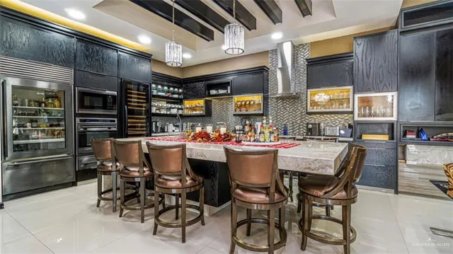 a dining area with stainless steel appliances kitchen island granite countertop a table chairs and a refrigerator